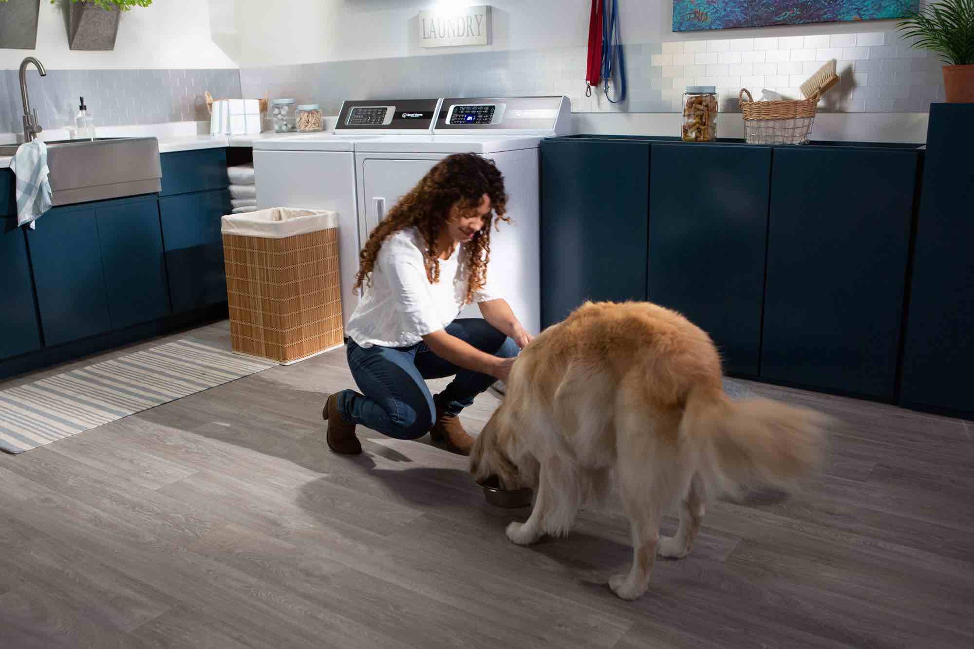 Speed queen in a laundry room with a woman and her dog
